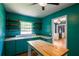 Vintage kitchen with turquoise cabinets, wood shelves, and a butcher block island at 3020 Washington Rd, East Point, GA 30344