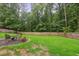 Lush backyard with a patio and well-maintained lawn surrounded by mature trees and a wooden fence at 3262 Mitsy Forest Way, Marietta, GA 30068