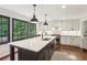 Spacious kitchen featuring a large island with modern lighting and views of the wooded yard at 3262 Mitsy Forest Way, Marietta, GA 30068