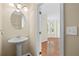 Half-bathroom with pedestal sink and natural light, accessible from the home's entry at 5159 Wellsley Bnd, Alpharetta, GA 30005