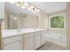 Bathroom with soaking tub, double sinks, and a large mirror at 5159 Wellsley Bnd, Alpharetta, GA 30005