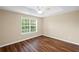 Neutral bedroom featuring a ceiling fan, wood floors, and a window with natural light at 5159 Wellsley Bnd, Alpharetta, GA 30005