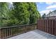 Back deck with a wooden fence and railing surrounded by trees at 5159 Wellsley Bnd, Alpharetta, GA 30005