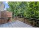 Back deck with a wooden fence surrounded by trees at 5159 Wellsley Bnd, Alpharetta, GA 30005