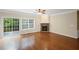 Spacious living room featuring hardwood floors, stone fireplace, and sliding glass doors at 5159 Wellsley Bnd, Alpharetta, GA 30005