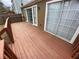 View of stained wood back deck with wood railing and access to the home through sliding glass doors at 6448 Charter Way, Lithonia, GA 30058