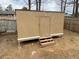 Neutral-colored outbuilding with wood door and steps to access the space at 6448 Charter Way, Lithonia, GA 30058