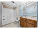 Well-lit bathroom with a tiled shower/tub combo, wood vanity, and ceramic tile floors at 7920 Silversmith Dr, Cumming, GA 30028