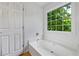 Bright bathroom features a soaking tub with a large window view of lush greenery at 7920 Silversmith Dr, Cumming, GA 30028