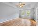 Bright main bedroom with wood floors, a tray ceiling, and large windows at 7920 Silversmith Dr, Cumming, GA 30028