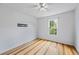 Bright bedroom with hardwood floors, ceiling fan, and large window with wooded views at 7920 Silversmith Dr, Cumming, GA 30028