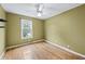 Bedroom with hard wood floors, ceiling fan, and a window allowing natural light at 7920 Silversmith Dr, Cumming, GA 30028