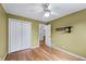 Bedroom featuring hardwood floors, ceiling fan, closet, and shelving at 7920 Silversmith Dr, Cumming, GA 30028