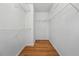 Spacious walk-in closet featuring wooden floors, white walls and wire shelves at 7920 Silversmith Dr, Cumming, GA 30028