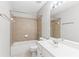 Well-lit bathroom features a tiled shower-tub combo and a white single-sink vanity for a fresh, clean look at 8750 Radford Ln, Suwanee, GA 30024