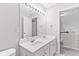Bright bathroom with a double sink vanity and a large mirror illuminated by modern vanity lights at 8750 Radford Ln, Suwanee, GA 30024