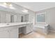 Bright bathroom featuring double sinks and a soaking tub near a window at 8750 Radford Ln, Suwanee, GA 30024