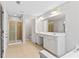 Large bathroom with double sink vanity, tiled floors and a glass door walk-in shower with natural light at 8750 Radford Ln, Suwanee, GA 30024