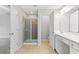 Bright bathroom featuring a glass shower, tan tile flooring, and white cabinets at 8750 Radford Ln, Suwanee, GA 30024