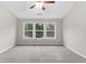 Spacious bedroom features neutral walls, plush carpet, and three large windows offering natural light and scenic views at 8750 Radford Ln, Suwanee, GA 30024