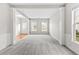 Bright and spacious living room with fresh grey carpet, white trim, large windows, and abundant natural light at 8750 Radford Ln, Suwanee, GA 30024