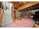 Unfinished basement with stairs leading to the upper level, an exposed ceiling, and pink painted floors at 125 Savannah Estates Dr, Atlanta, GA 30350