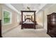 Spacious primary bedroom featuring a four-poster bed, carpet and dark wood furniture at 125 Savannah Estates Dr, Atlanta, GA 30350