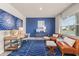 Bright living room with blue accent wall, modern furniture, and large windows with natural light at 237 Paisley Way, Locust Grove, GA 30248