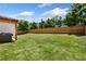 Landscaped backyard featuring a lawn, wooden fence, and a covered hot tub at 247 Creek View Ln, Acworth, GA 30102