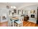 Bright dining area with white wooden chairs, hardwood floors, and an open view to the living room at 247 Creek View Ln, Acworth, GA 30102