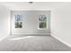 Cozy bedroom with plush gray carpet and two windows that offer scenic outdoor views at 3926 Lockaby Way, Lawrenceville, GA 30044