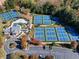Aerial view of community amenity center with tennis courts, pool, parking and playground amidst colorful fall foliage at 48 Hampton Ter, Dallas, GA 30157