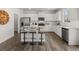 Bright kitchen with white cabinets, stainless steel appliances, granite countertops and a center island with barstool seating at 48 Hampton Ter, Dallas, GA 30157