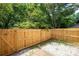 Backyard patio with privacy fence, white stone ground cover, and mature trees at 7750 Roswell Rd # 3D, Atlanta, GA 30350