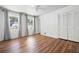 Bright bedroom features wood floors, neutral walls, ceiling fan, two windows, and closet with louvered doors at 7750 Roswell Rd # 3D, Atlanta, GA 30350