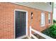 Close-up of the townhouse entrance with a brick facade, a dark door, and a well-lit porch area at 7750 Roswell Rd # 3D, Atlanta, GA 30350