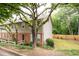 Exterior view of a well-maintained townhouse with brick and siding, surrounded by lush greenery and trees at 7750 Roswell Rd # 3D, Atlanta, GA 30350