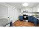 Bright kitchen featuring white and blue cabinets, stainless steel appliances, granite countertops, and hardwood floors at 7750 Roswell Rd # 3D, Atlanta, GA 30350