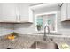 Kitchen sink with granite countertops, white cabinets, and a window view for a bright and airy space at 7750 Roswell Rd # 3D, Atlanta, GA 30350
