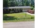A brick home with an attached garage and driveway is set against an unkempt lawn and adjacent to a trash dumpster at 1024 Topaz Lane, Villa Rica, GA 30180