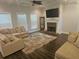 Bright living room featuring a cozy fireplace, dark wood floors, and plush sofas at 124 Archstone Sq, Mcdonough, GA 30253