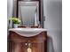 Charming bathroom boasts a wood vanity with a framed mirror and yellow flowers at 2972 Aspen Woods Entry, Atlanta, GA 30360