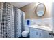 Traditional bathroom with a decorative mirror, vanity sink, and a shower with a patterned curtain at 5410 Rosser Rd, Stone Mountain, GA 30087