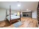 Spacious bedroom with four poster bed, brick fireplace, and modern flooring at 5410 Rosser Rd, Stone Mountain, GA 30087