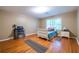 Bedroom with hardwood floors, a white bed frame, and a desk next to a window at 5410 Rosser Rd, Stone Mountain, GA 30087