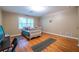 Bright bedroom features wood floors, a window with blinds, and a simple bed with colorful pillows at 5410 Rosser Rd, Stone Mountain, GA 30087