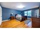 Bedroom featuring blue walls, hardwood floors, and abundant natural light from a large window at 5410 Rosser Rd, Stone Mountain, GA 30087