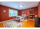 Bedroom featuring rich red walls, hardwood floors, and a large window with natural light at 5410 Rosser Rd, Stone Mountain, GA 30087