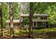 Two-story home featuring stone accents, surrounded by mature trees and a lush green lawn at 5410 Rosser Rd, Stone Mountain, GA 30087