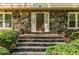 Stone front entrance with a welcoming front door, flanked by windows and manicured landscaping at 5410 Rosser Rd, Stone Mountain, GA 30087
